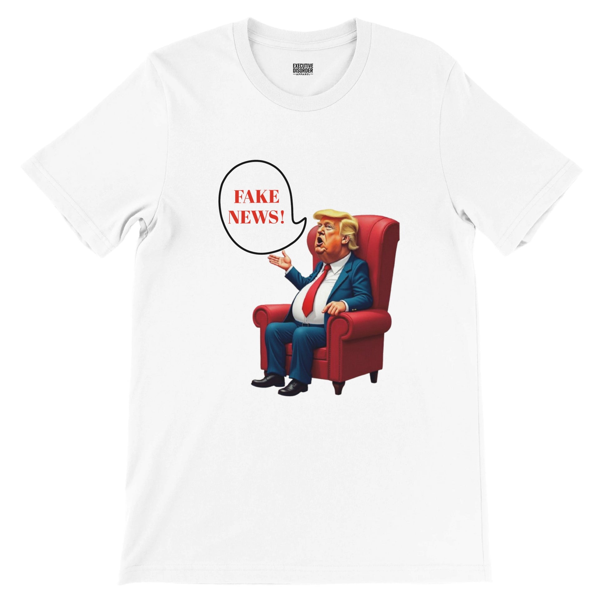 White t-shirt with a colourful cartoon-style caricature of a suited, orange-tinted man sitting in a red armchair, raising one hand and shouting ‘FAKE NEWS!’ in a speech bubble