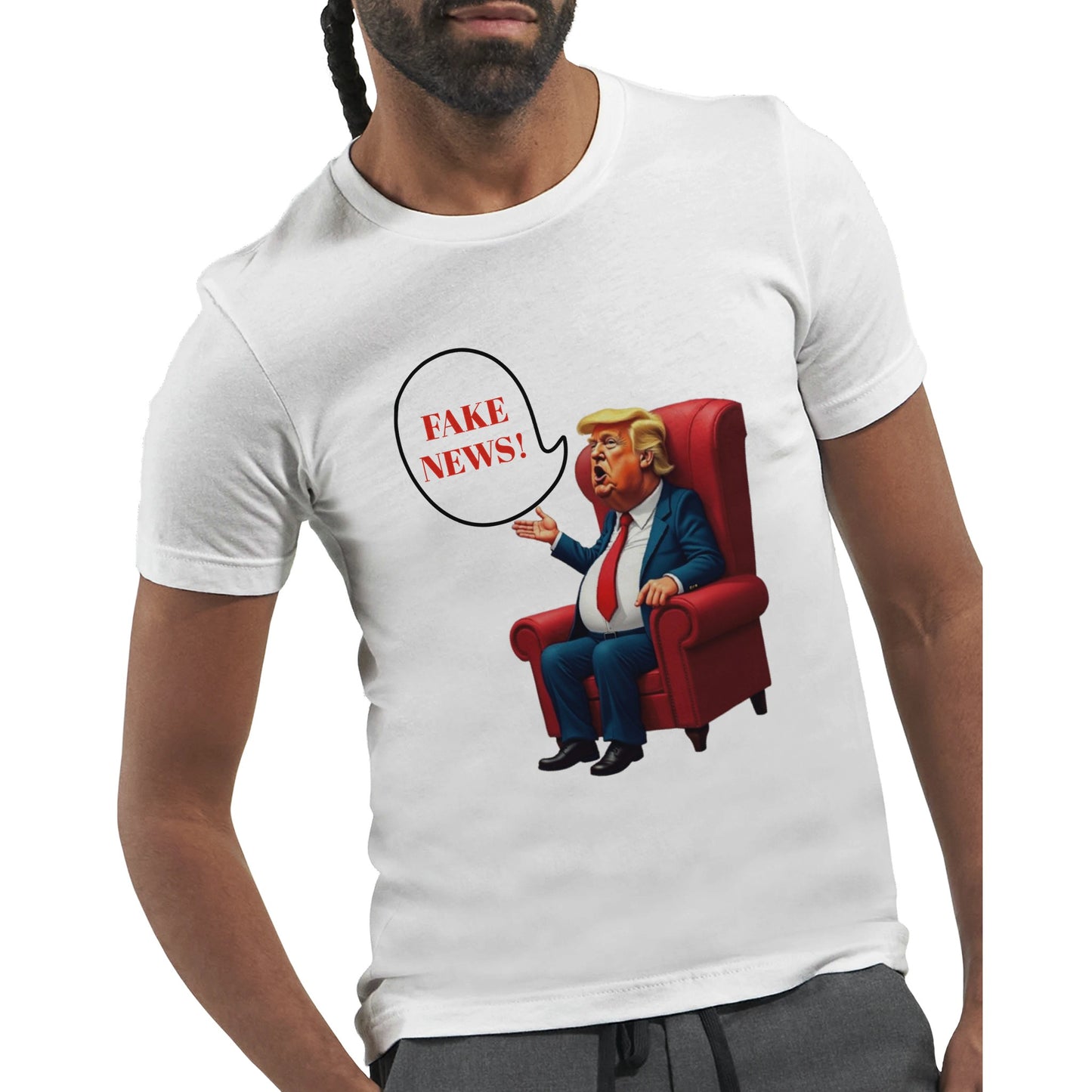 White t-shirt with a colourful cartoon-style caricature of a suited, orange-tinted man sitting in a red armchair, raising one hand and shouting ‘FAKE NEWS!’ in a speech bubble